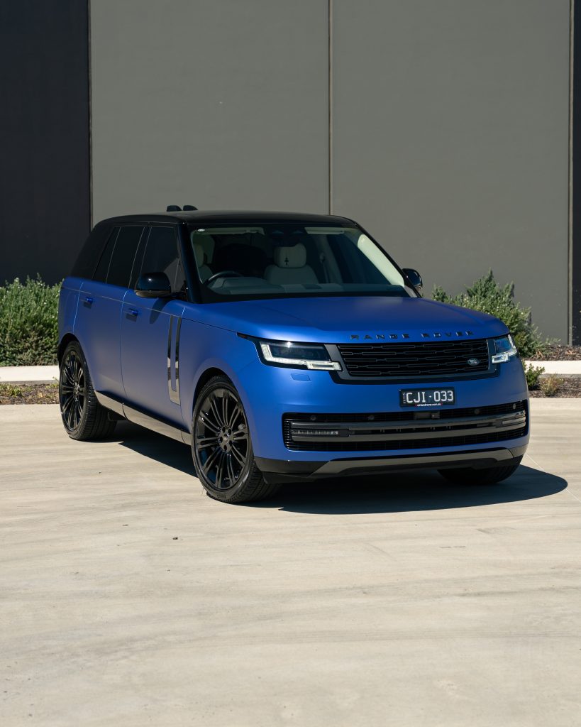 Blue Range Rover SUV parked outside a building